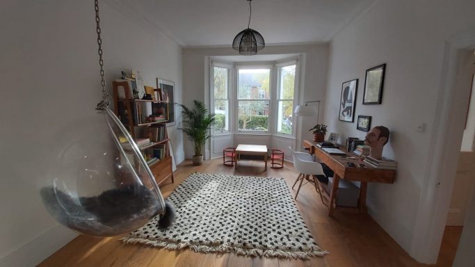 Large bright room with hanging chair, wooden flooring