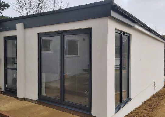 Single story side extension with bi-fold doors, white render