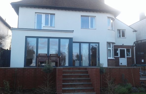 A modern single story extension with bi-fold doors finished in with white render