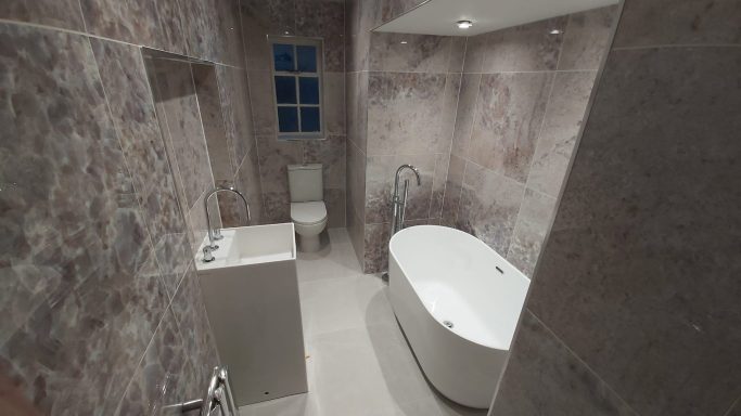 We created this stylish bathroom, walls are decorated in large marble effect porcelain tiles, a Japanese bath & floor standing bath tap.